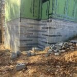 A house under construction with bricks and cement, showcasing the building process and foundation work