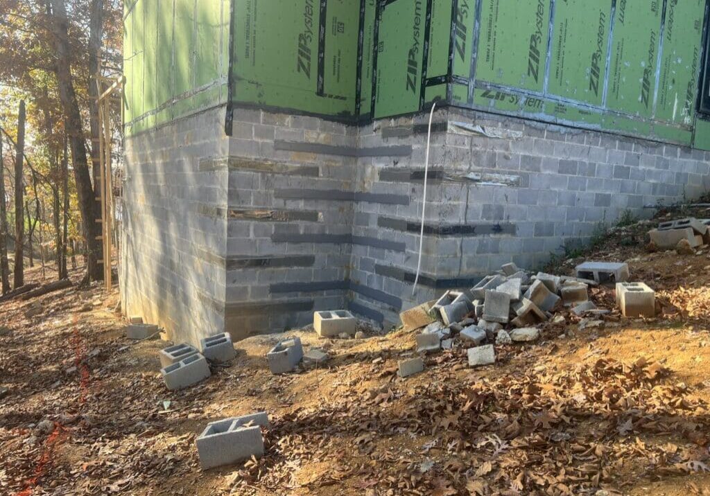 A house under construction with bricks and cement, showcasing the building process and foundation work